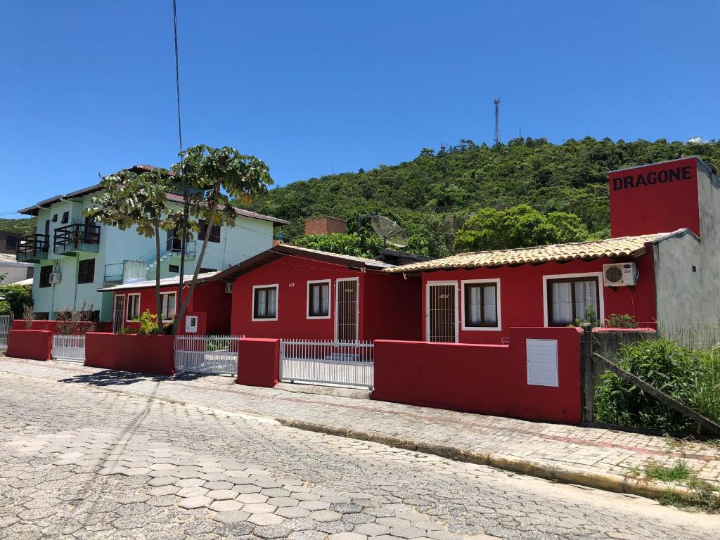 una fila de casas rojas al lado de una calle en Pousada Residencial Família Dragone, en Bombinhas