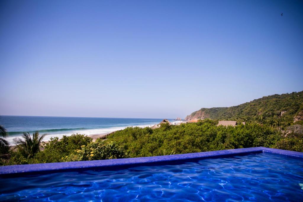 a swimming pool with a view of the beach at Hotel El Copal in Mazunte