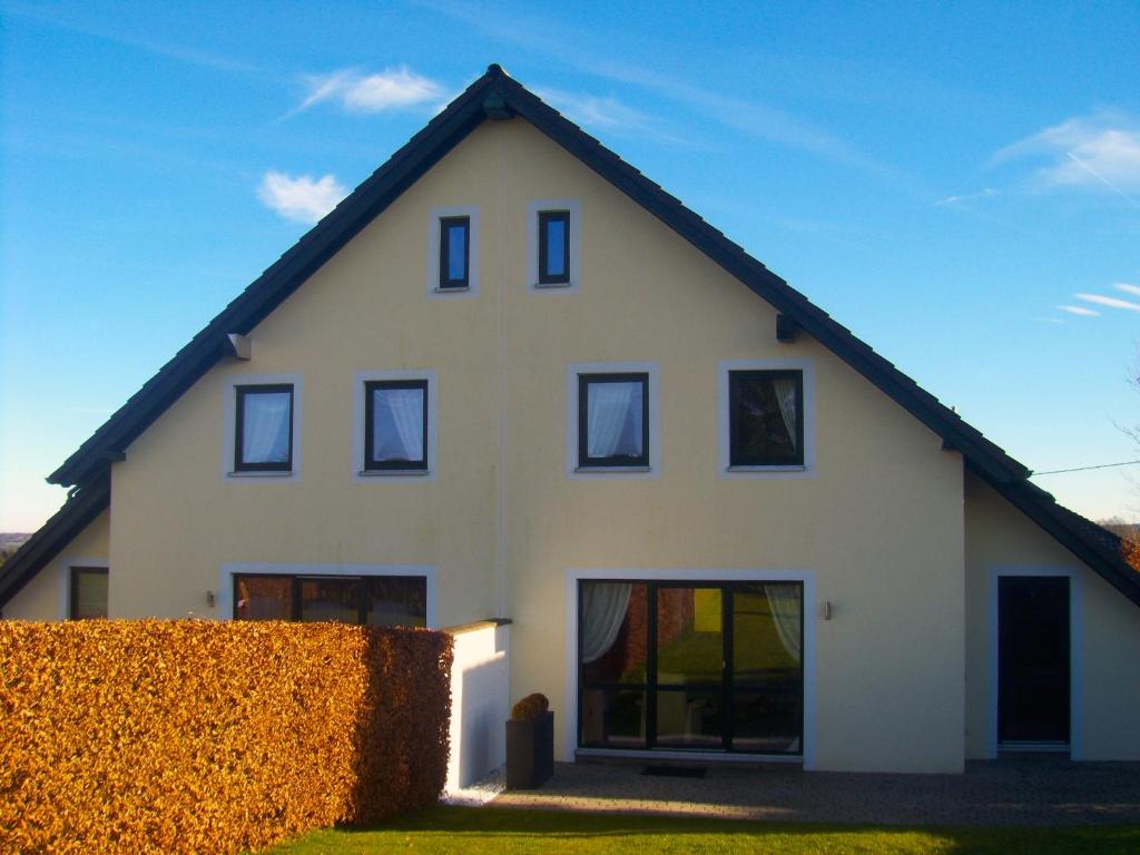 uma casa branca com um telhado preto em Ferienhäuser Schröder em Monschau