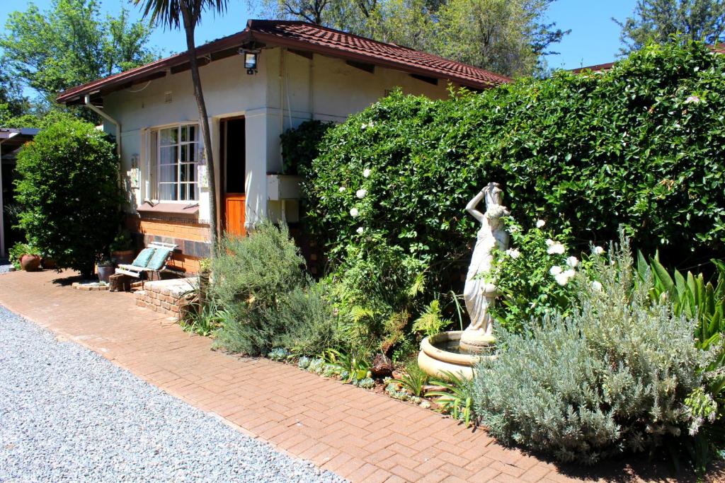 a garden with a statue in front of a house at Grace Accommodation Centurion in Centurion