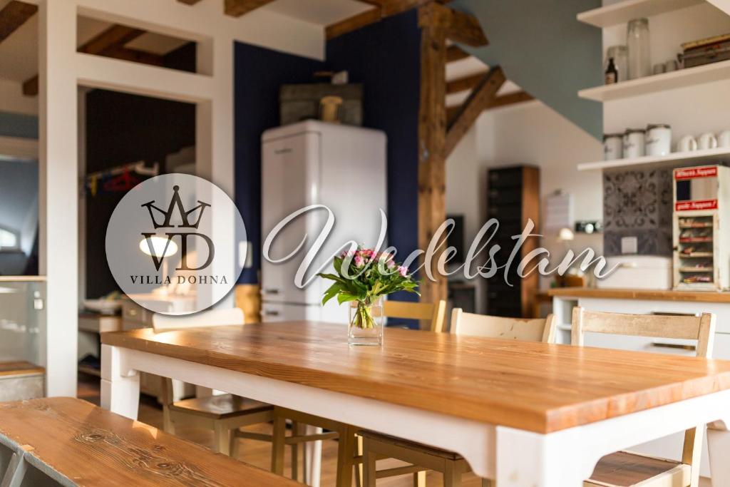 ein Esszimmer mit einem Tisch und einem Kühlschrank in der Unterkunft Villa Dohna - Apartment Wedelstam in Leipzig
