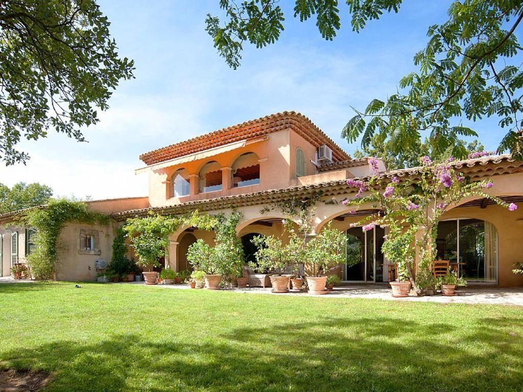 a large house with a yard with potted plants at Villa Elaiza in Saint-Tropez