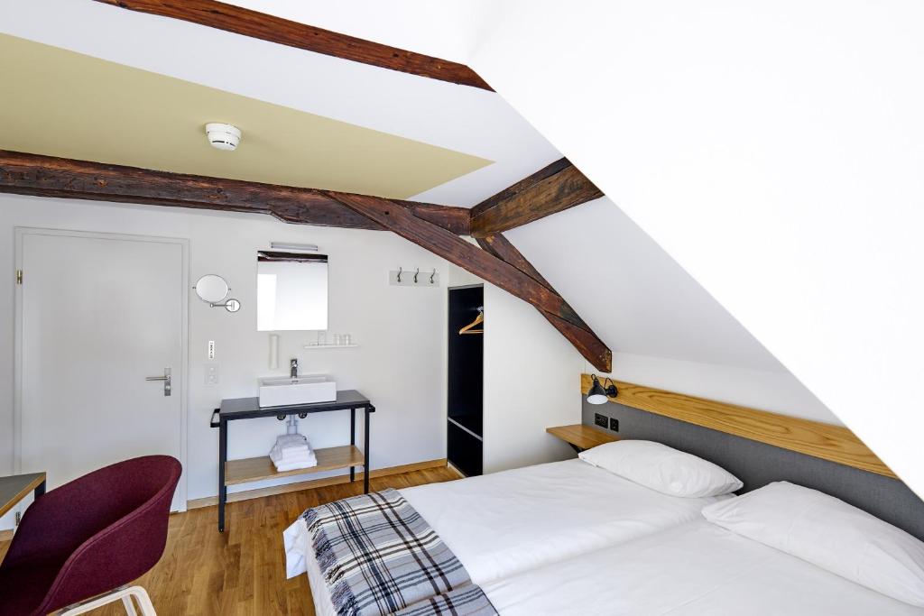 1 dormitorio con 1 cama, mesa y sillas en Hotel Jakob en Rapperswil-Jona