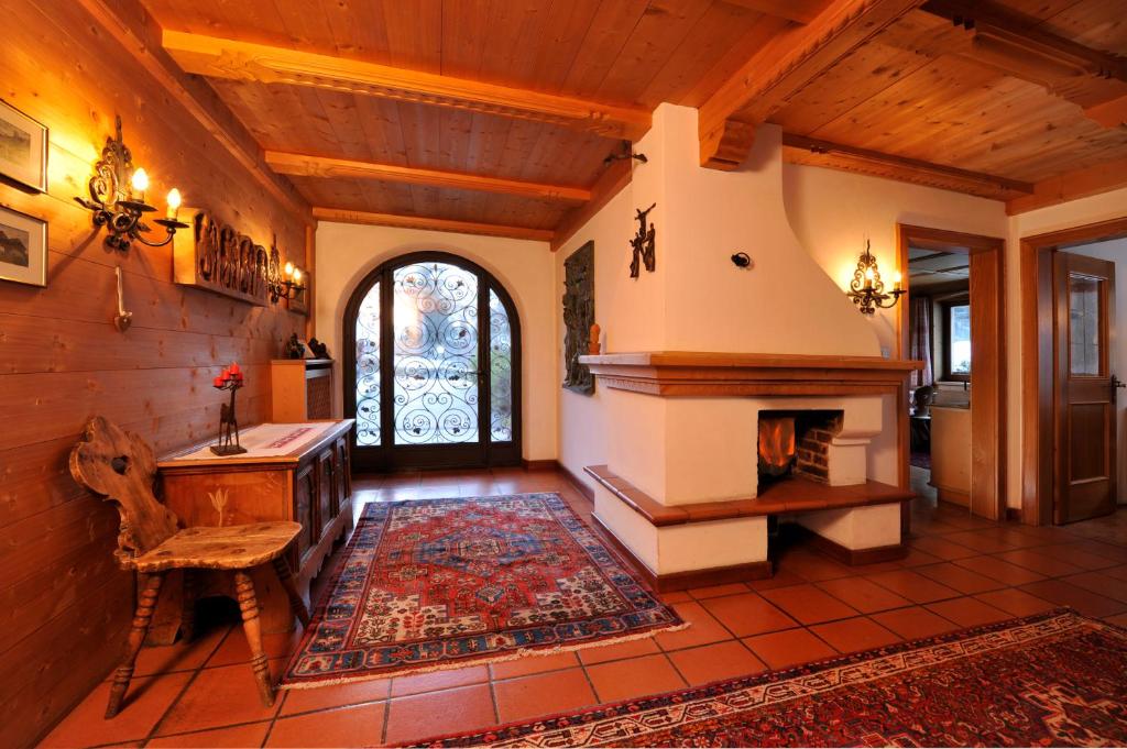 sala de estar con chimenea y techo de madera en Apartments Thaler Irina, en Ortisei