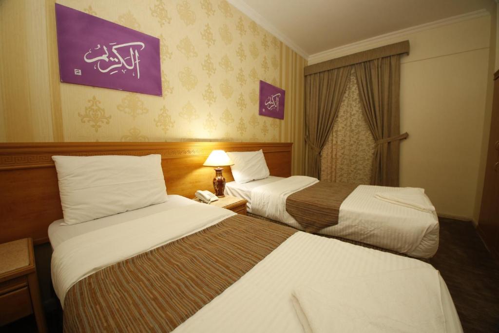 a hotel room with two beds and a window at Guest Time Hotel in Medina