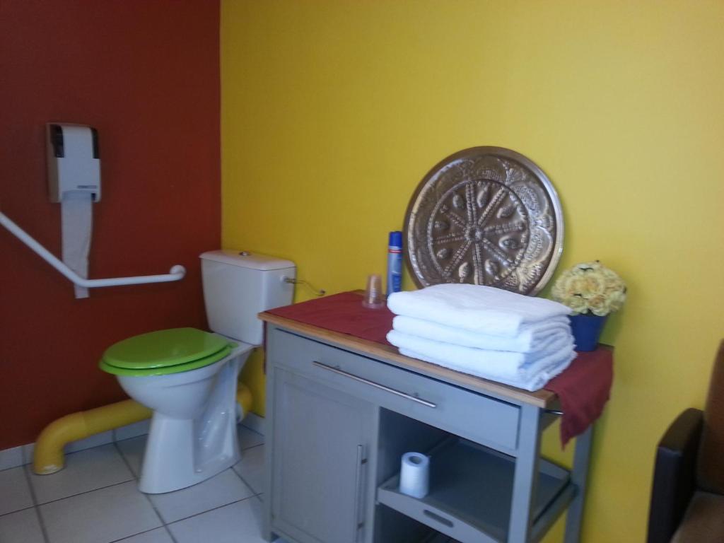 La salle de bains est pourvue de toilettes et d'un tas de serviettes. dans l'établissement Chambres D'Hôtes Le Domaine de la Marnière, à Villainville