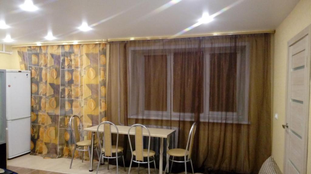 トヴェリにあるАпартаменты на Володарскогоのダイニングルーム(テーブル、椅子、窓付)