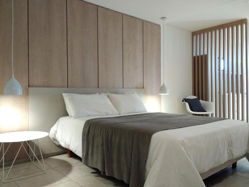 1 dormitorio con 1 cama grande y 1 silla en Departamentos Lugar en Córdoba
