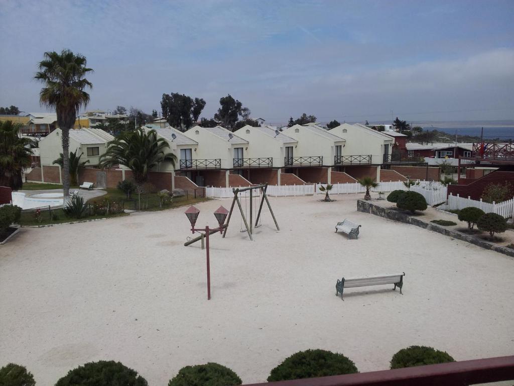a park with a playground and a swing at Bahia Inglesa Apartamentos in Bahia Inglesa