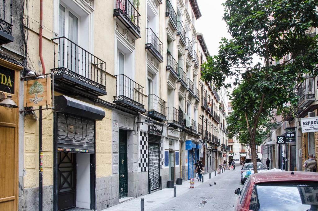 una calle de la ciudad con edificios y un coche rojo en Pelayo, 8, en Madrid