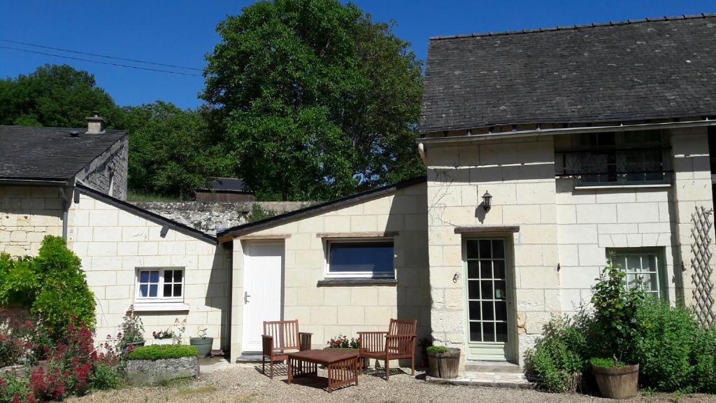 a house with chairs and a table in front of it at Gite 3* pour 2 "Vert Campagne" in Grézillé