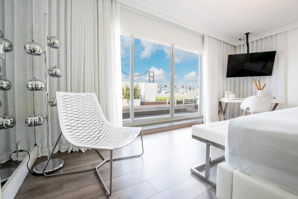 una camera con letto, scrivania e sedia di President Hotel a Miami Beach