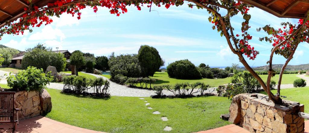 a view of a garden with a stone wall at Hotel Spartivento in Chia