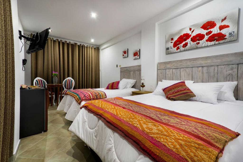 um quarto de hotel com duas camas e uma mesa em El Encanto em Lunahuaná