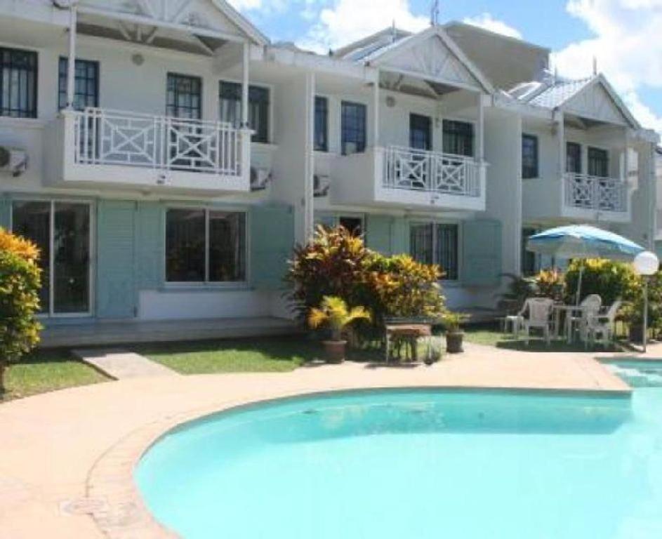 une grande maison avec une piscine devant dans l'établissement Casa Marina- Flic en Flac - Beach is right in front of the Villa-Just cross the road, à Flic-en-Flac