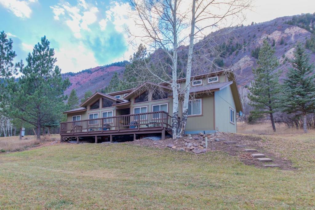 una grande casa con terrazza e montagna di Chair Mountain Cabin at Filoha Meadows a Redstone