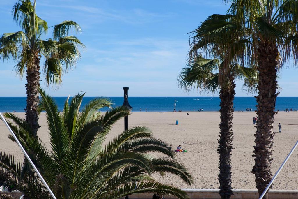 バレンシアにあるApartamento playa Las Arenasのヤシの木と海の景色を望む