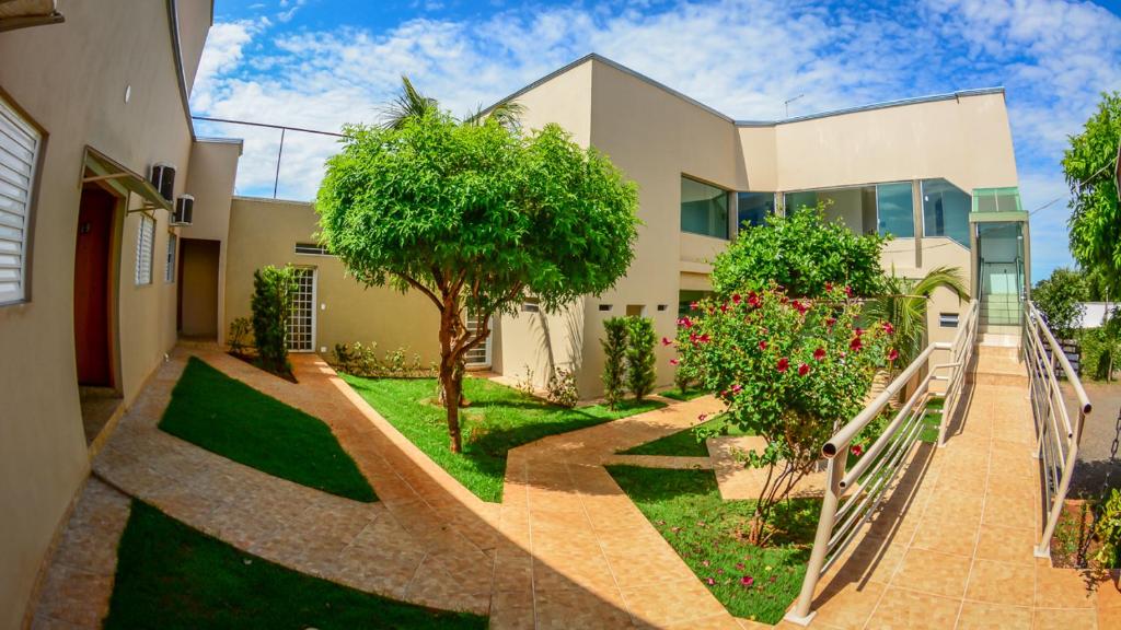 una casa con un jardín delante de ella en Hotel Winner, en Barretos