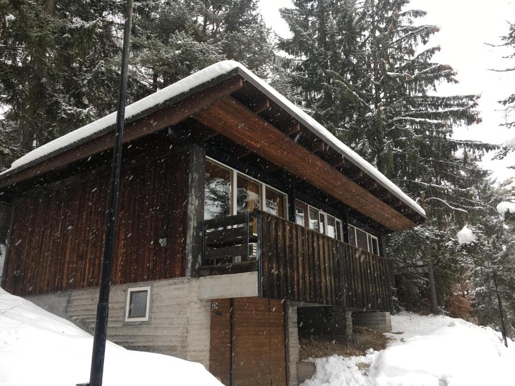 a house with a deck in the snow at Villa Borca di Cadore in Borca di Cadore