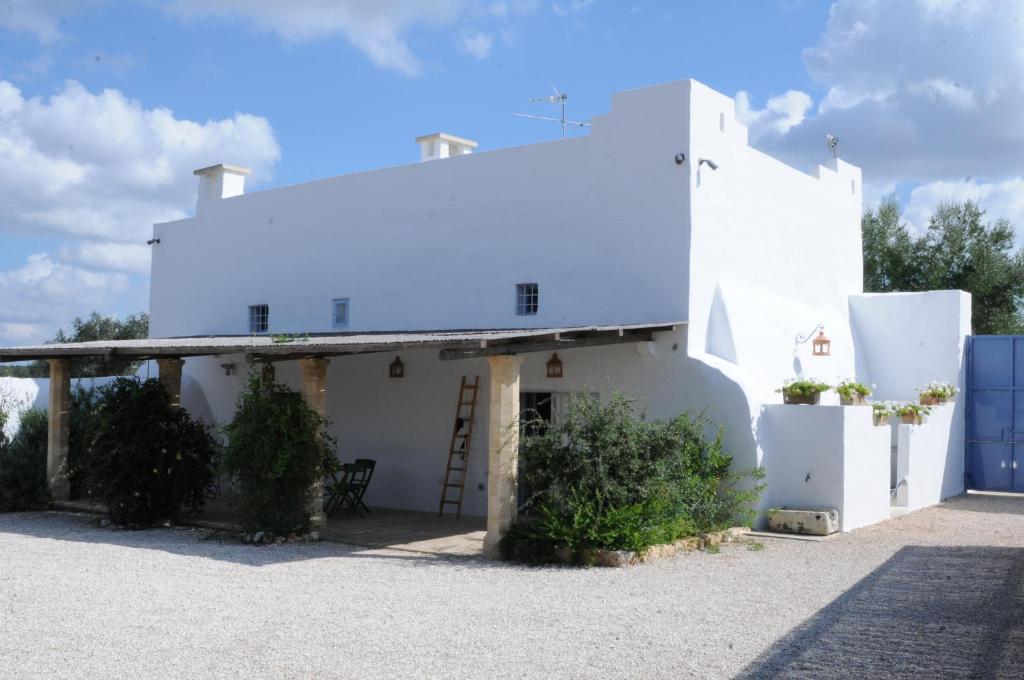 Uma casa branca com uma escada ao lado. em Masseria Caposella em Ugento