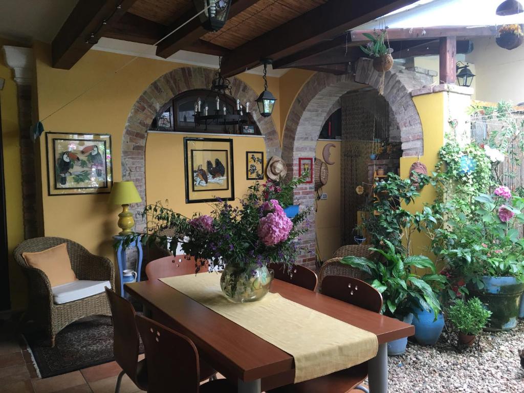 a dining room with a table and some plants at L'angolo antico in Oristano