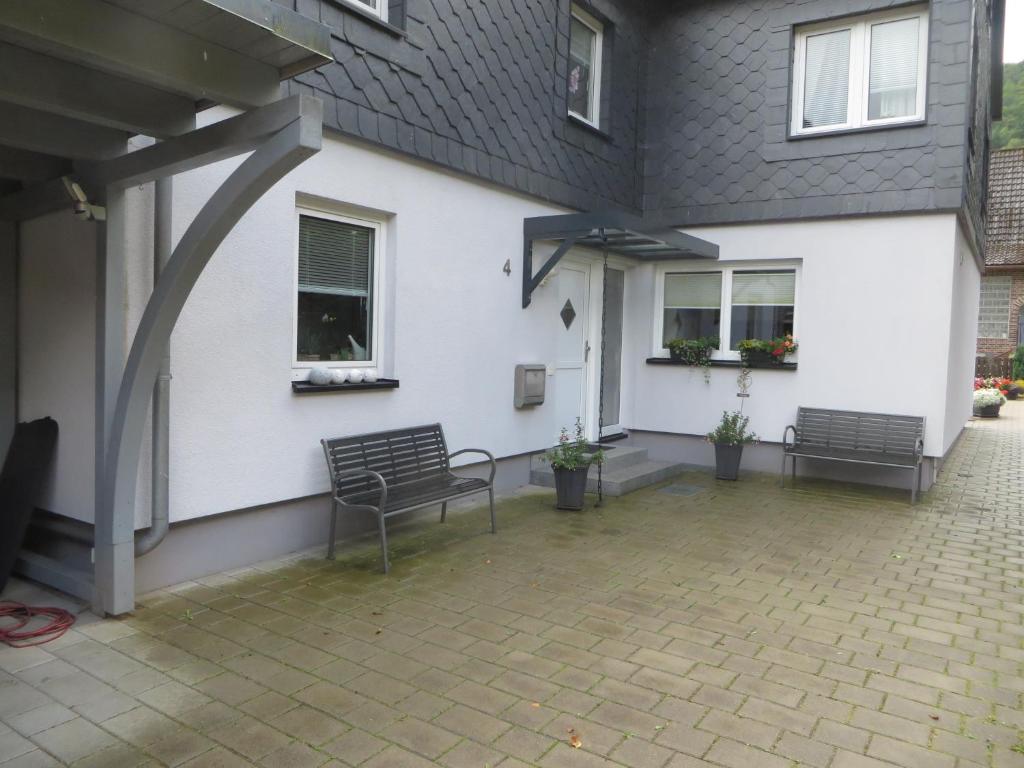 a patio with two benches in front of a house at Ferien Apartment Meister in Zorge