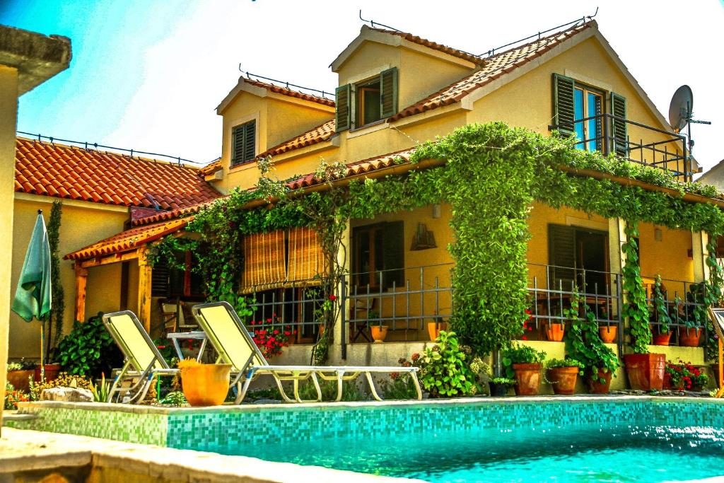 a house with a swimming pool in front of a house at Villa Kolacje in Škrip