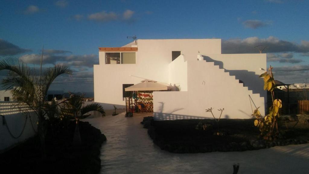 - un bâtiment blanc avec un escalier devant dans l'établissement Alma en el Mar, à Tinajo