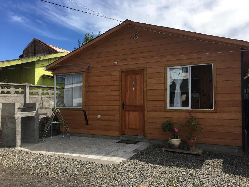 a small wooden house with a door and a window at Cabañas El Sol de Dichato in Dichato
