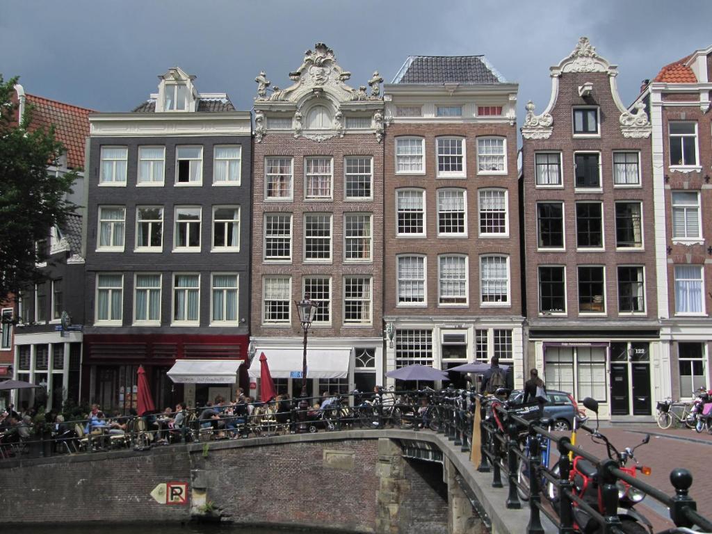 a group of buildings with tables and bikes on a bridge at Luxury Prinsengracht Canal House Jordan Area in Amsterdam