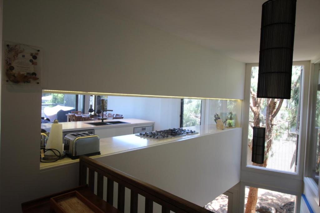 a kitchen with a large mirror on the wall at Lorne Holiday House in Lorne