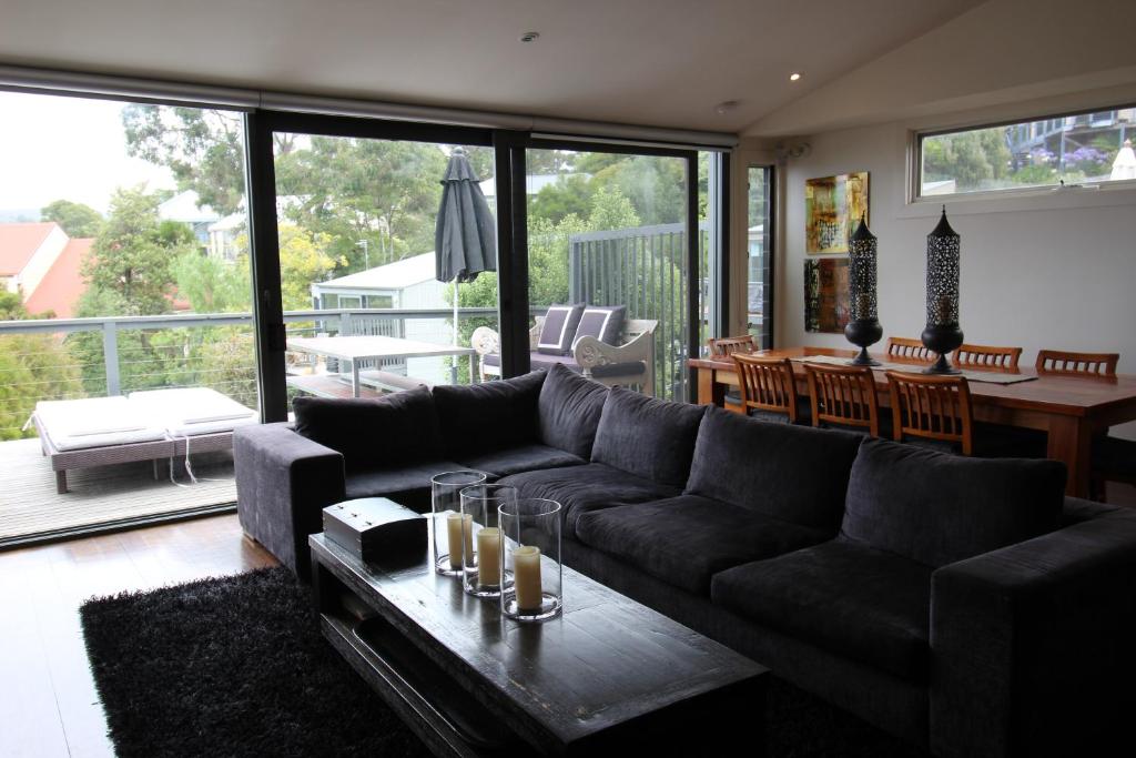 a living room with a couch and a table at Lorne Holiday House in Lorne