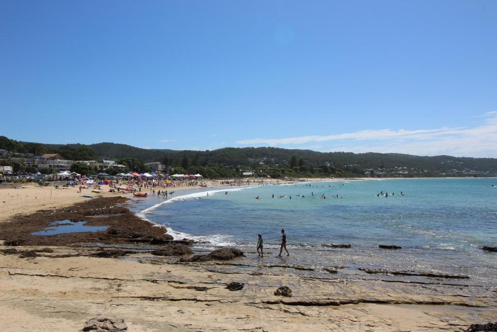 a group of people on a beach with the ocean at Lorne Holiday House in Lorne