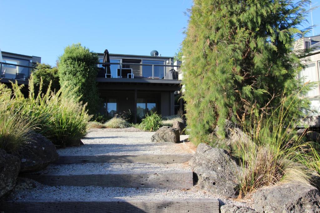 a path leading to a house with trees and rocks at Lorne Holiday House in Lorne