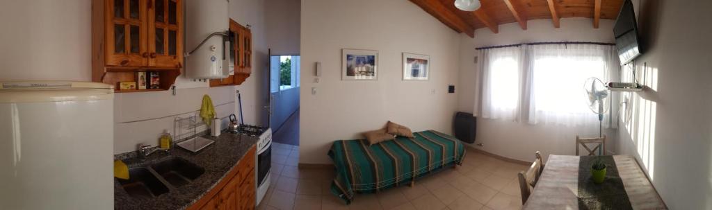 sala de estar con cocina con sofá y ventana en Belgrano 238 en Capilla del Monte