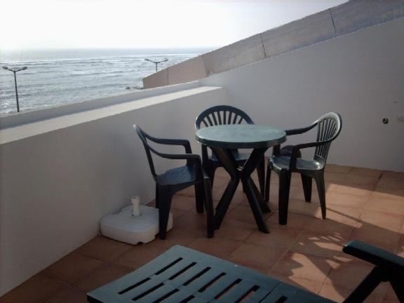 a table and chairs on a balcony with the ocean at Casa da muralha in Figueira da Foz
