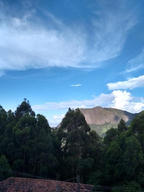 a view of trees and mountains with a blue sky at Pedra Do Imperador in Nova Friburgo