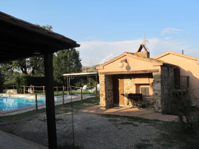 マンチャーノにあるResidenza D'Epoca Le Pisanelleの庭にプールとグリルがある家