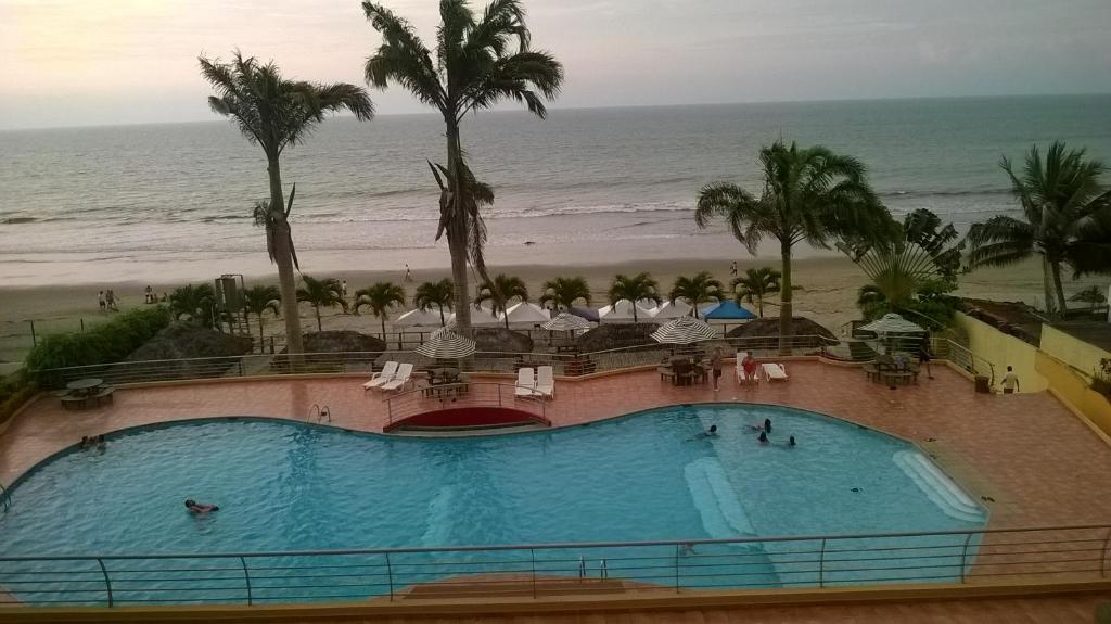 a view of a swimming pool and the beach at Departamento Torresol Tropical in Tonsupa