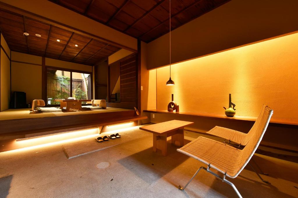Zimmer mit einer Bank, einem Tisch und einem Waschbecken in der Unterkunft Kuraya Kiyomizu Gojo in Kyoto