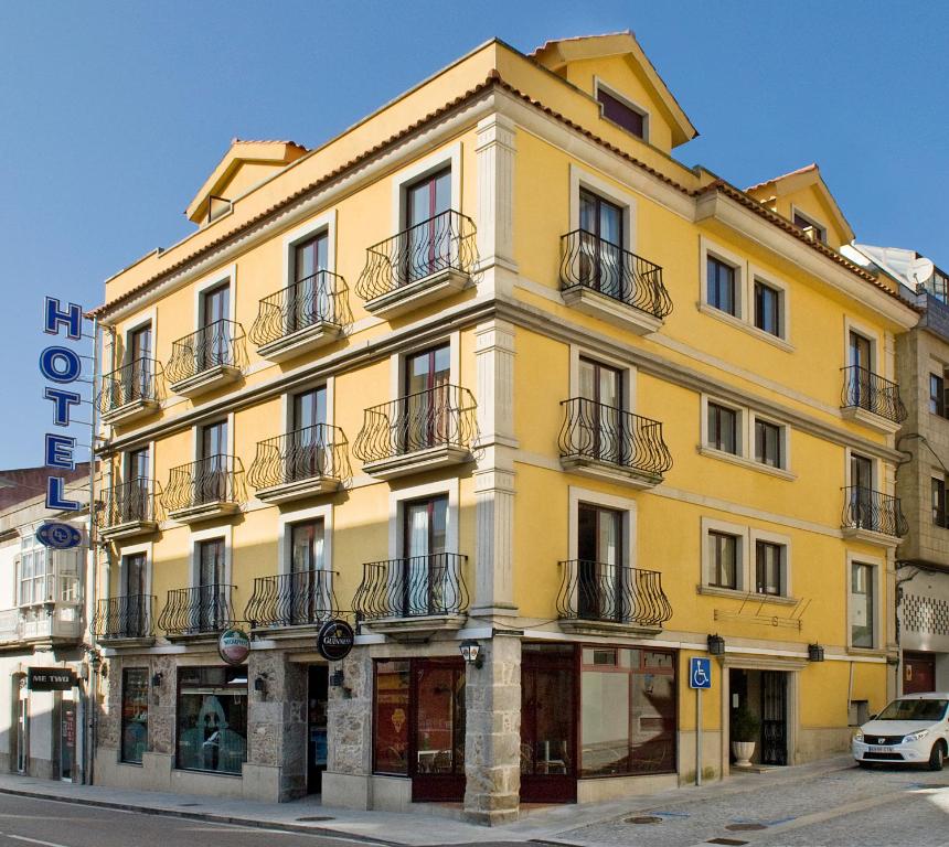 un edificio amarillo al lado de una calle en Hotel Celta, en A Guarda