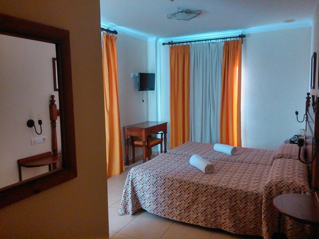 プエルト・レアルにあるHotel Las Canteras de Puerto Realのベッドと鏡が備わるホテルルーム