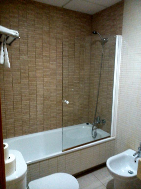 a bathroom with a tub and a toilet and a sink at Hotel Las Canteras de Puerto Real in Puerto Real