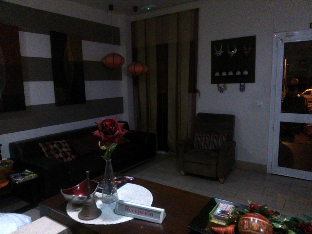 a living room with a vase of flowers on a table at Hotel Las Canteras de Puerto Real in Puerto Real