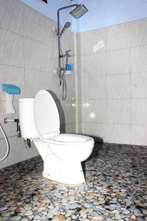 a bathroom with a toilet with a shower and a shower at Danke Lodge in Labuan Bajo