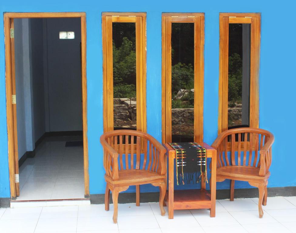 two chairs and a table in front of two mirrors at Danke Lodge in Labuan Bajo