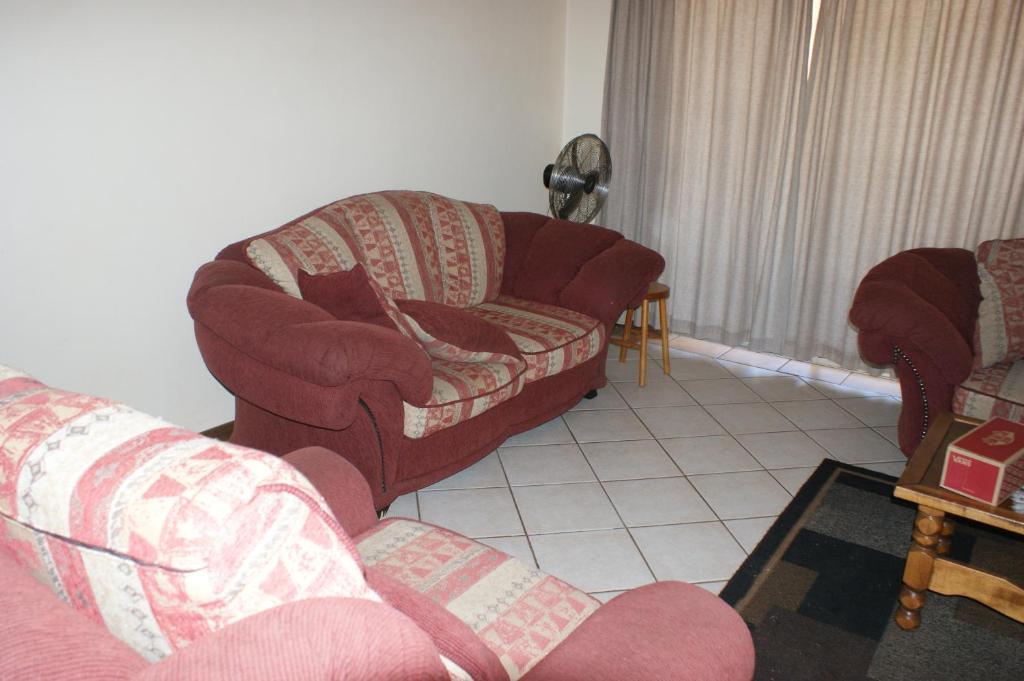 a living room with two chairs and a couch at Eric's Apartments in Centurion
