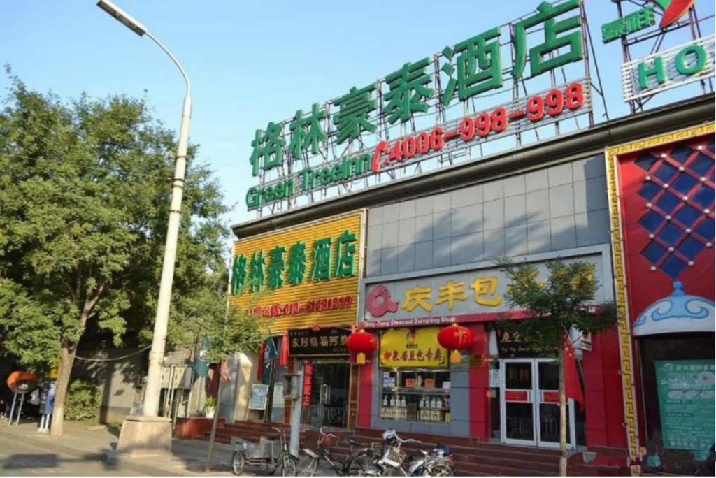 un edificio con un cartel en el costado en GreenTree Inn Beijing Dongcheng District Wangfujin South Luogu Lane Houhai Express Hotel, en Beijing