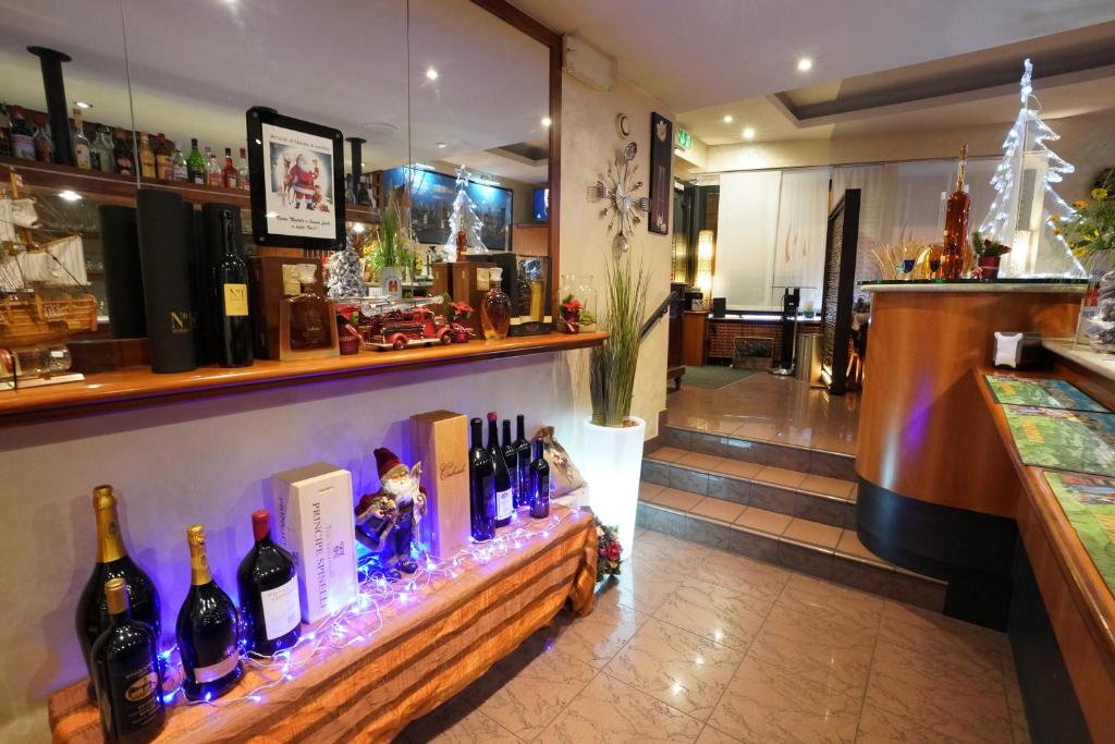 a bar with a display of wine bottles at Hotel Bahnhof Haus in Chiasso