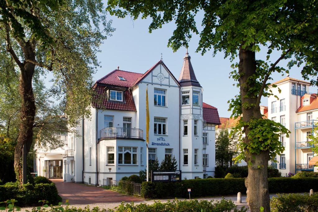 uma grande casa branca com uma torre em Ringhotel Strandblick em Kühlungsborn